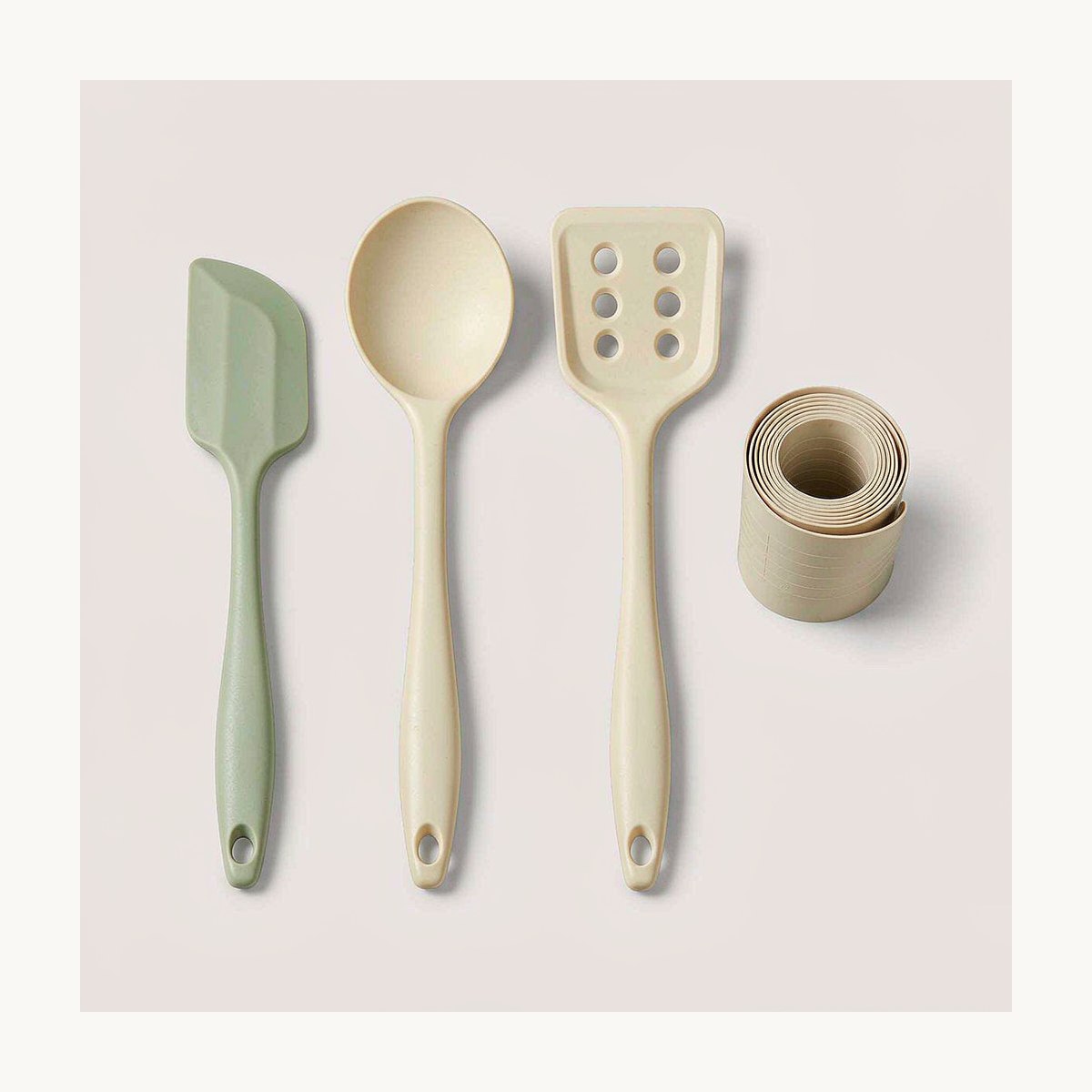 Set of blank food-grade silicone kitchen utensils with a rolled baking mat